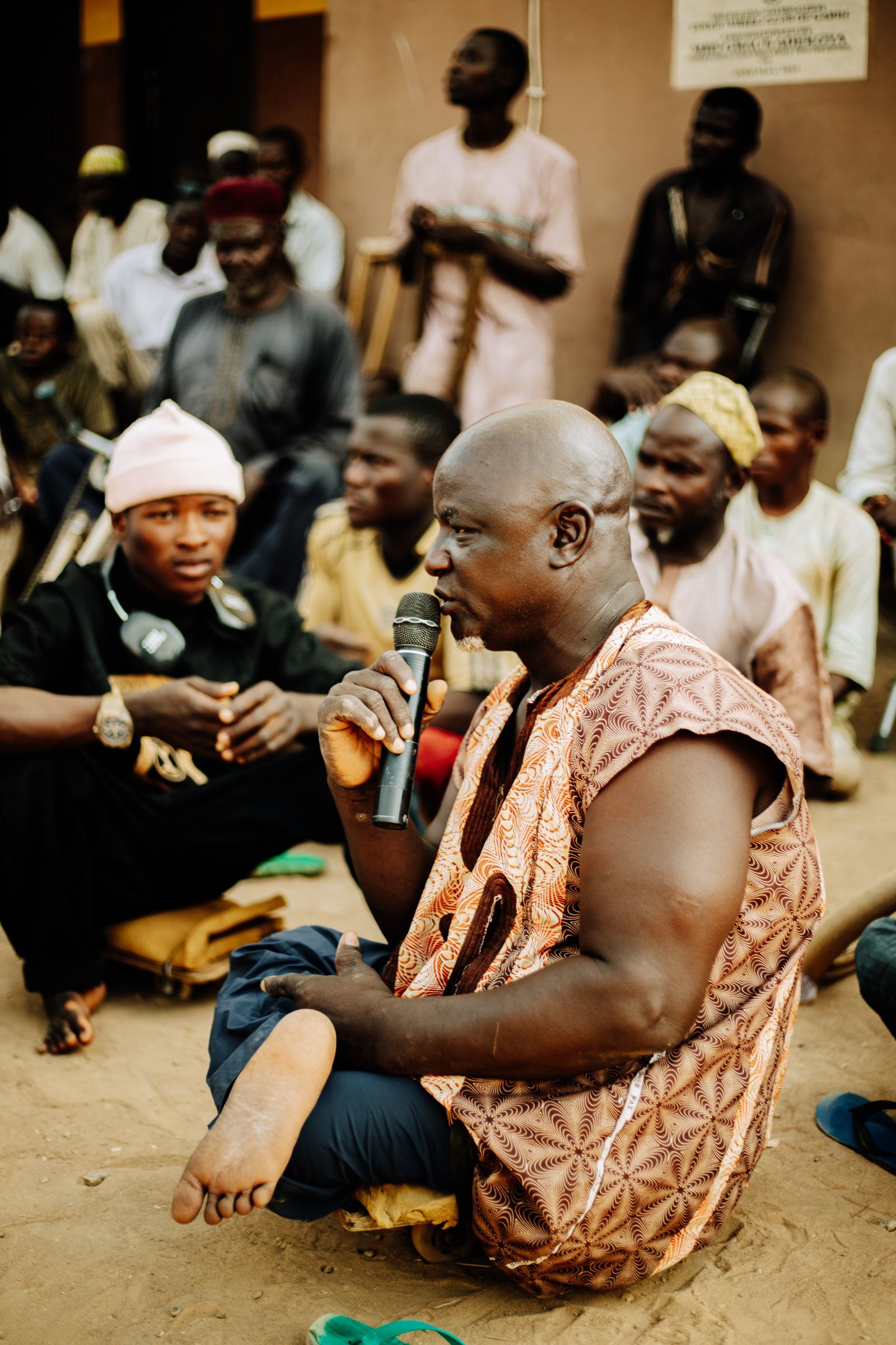A community gathered outdoors listening to a speaker