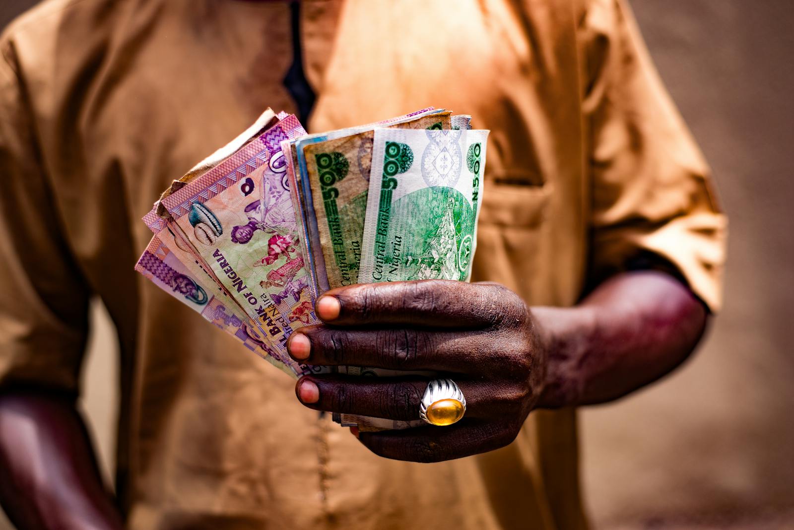 A man holding banknotes in his hands outdoors